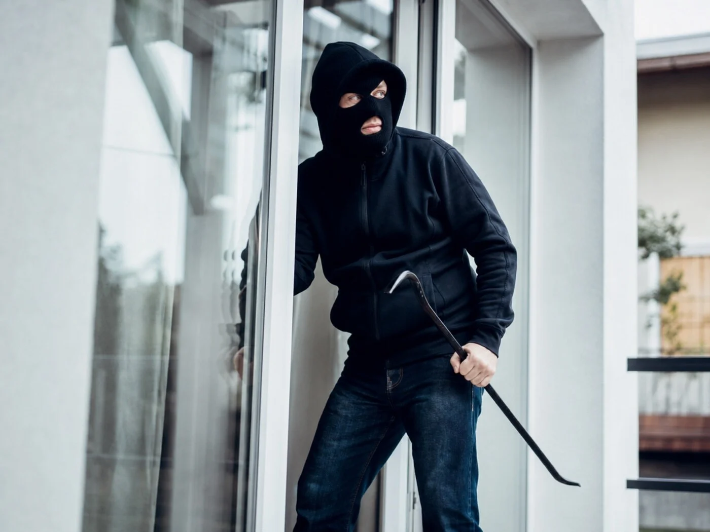 Un cambrioleur force une porte vitrée